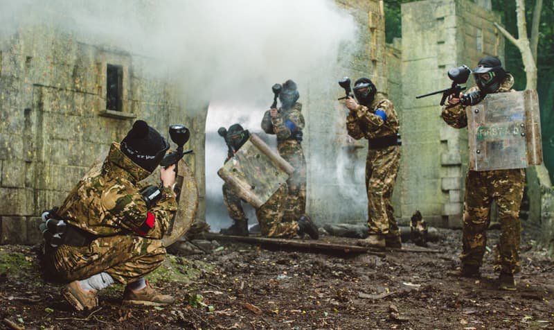Paintball players in action with smoke grenades