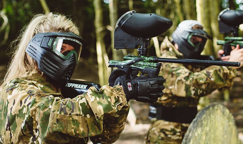 Paintball players aiming in forest